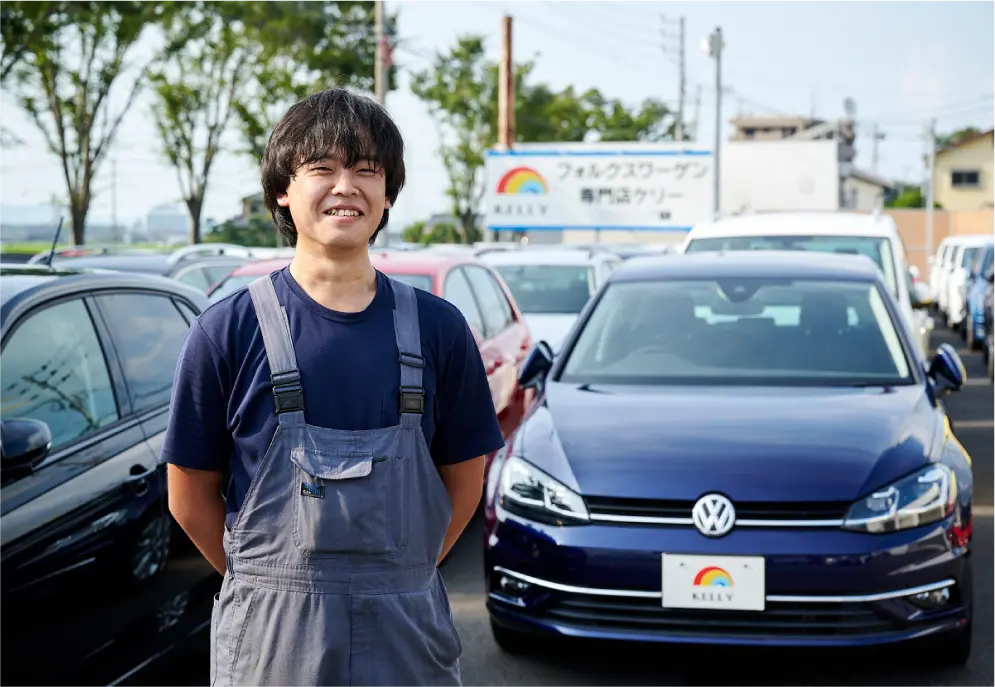 売り場の前で両手を後ろで組み微笑む男性の写真