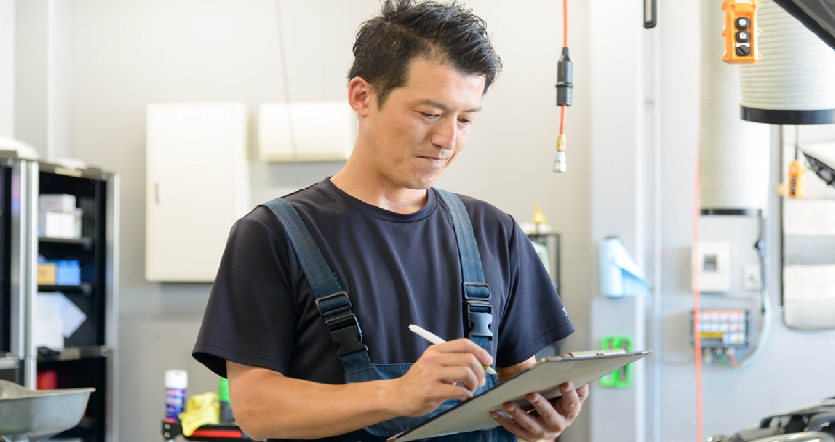 ペンを手にした職員がクリップボードの紙に書き込んでいる様子